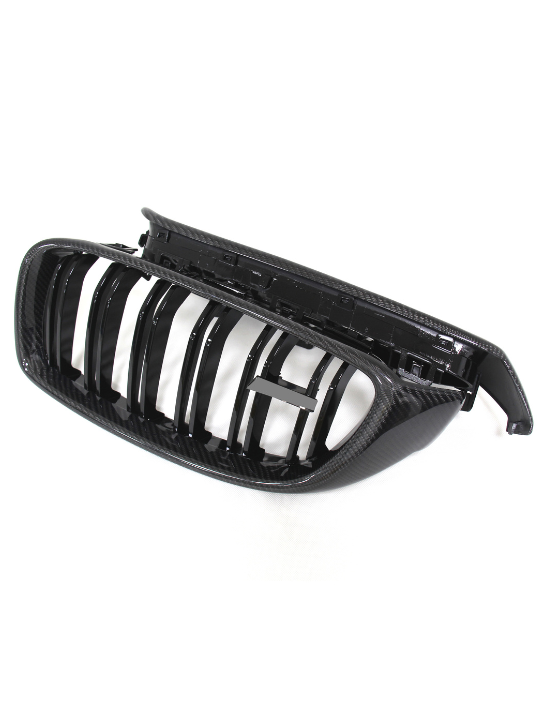 A black, glossy car grille with vertical slats sits in an angled position, showcasing its curved design and detached structure, against a plain white background.