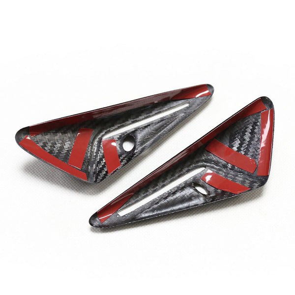 Two carbon fiber car parts with red accents and holes, positioned on a white surface. Each piece is triangular with a glossy finish, showing a textured pattern.