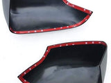 Two black plastic automotive parts feature red adhesive strips along the edges, labeled 