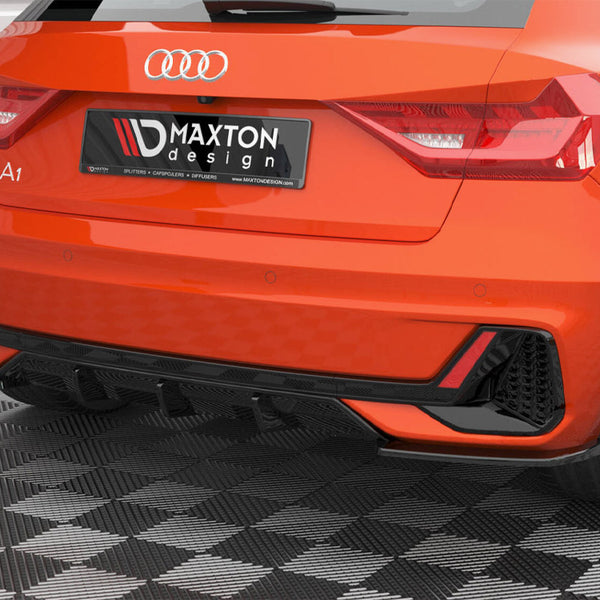 A red Audi A1 is parked on a checkered floor, displaying a black "Maxton design" rear bumper in a garage-like setting.