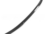 A long, curved, black car trim piece, likely a spoiler or edge guard, rests against a plain white background.