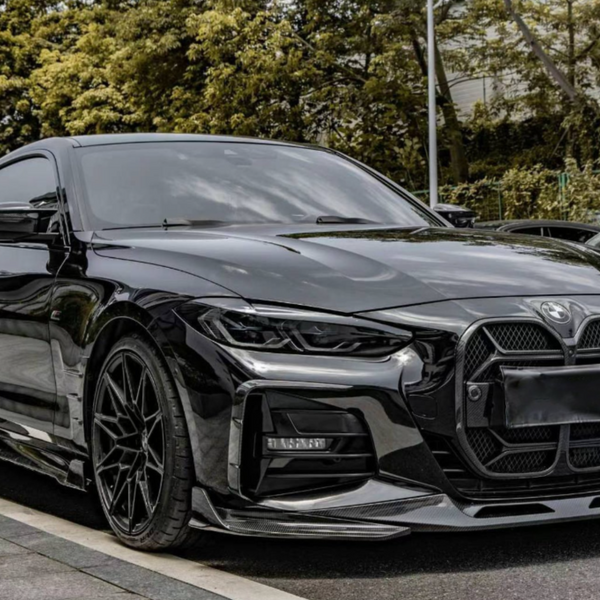 A sleek black sports car is parked on a street lined with trees and other vehicles, its glossy surface reflecting the surroundings, emphasizing its modern, aerodynamic design.