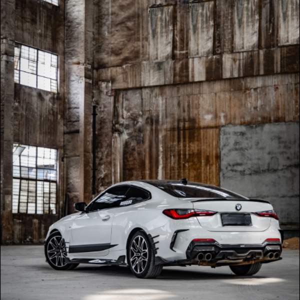 A white sports car is parked in an abandoned warehouse with large, rusted windows and a gritty, industrial atmosphere.