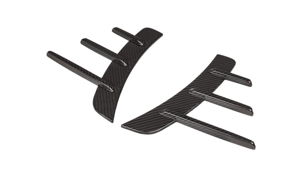 Two curved carbon fiber car diffusers with vertical fins, lying against a white background.