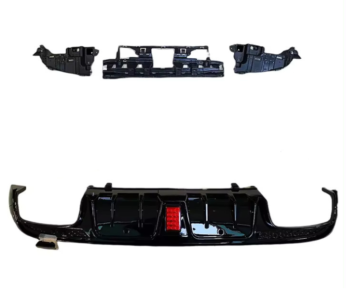 Black car bumper components are arranged on a white background. The largest piece features a red reflector at the center, while smaller components include grille sections and side parts.