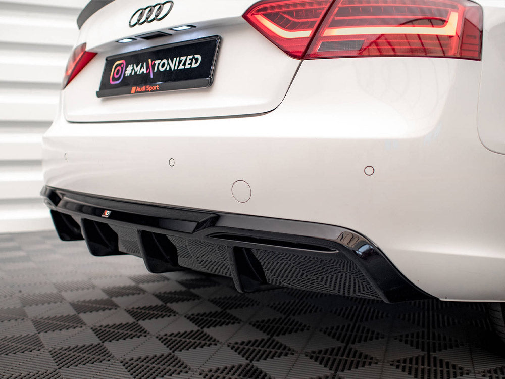 A white car's rear, featuring visible black diffuser and red taillights, is in a garage. The license plate reads "#MAXTONIZED." The floor has a checkered pattern.