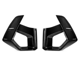 Two carbon fiber vent covers facing each other, featuring sleek, angular designs. They are positioned against a plain white background, highlighting their glossy texture and geometric shapes.