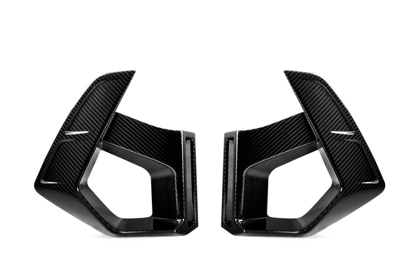 Two carbon fiber vent covers facing each other, featuring sleek, angular designs. They are positioned against a plain white background, highlighting their glossy texture and geometric shapes.