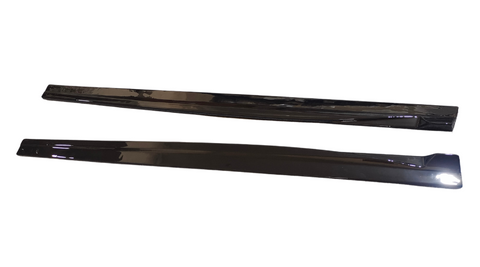Two long, black plastic strips are placed parallel on a white background, reflecting light. They appear smooth and shiny, with slightly curved edges.