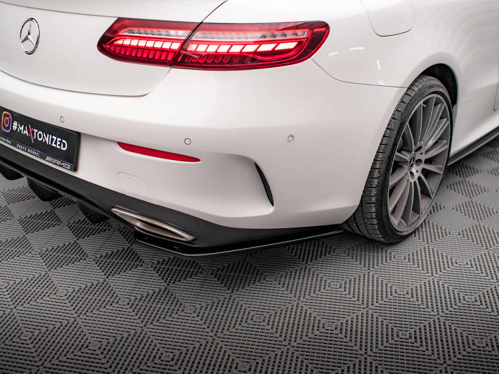 A white car with illuminated tail lights sits on a textured floor. The rear bumper features a dual exhaust, and a license plate displays "#MAXTONIZED."