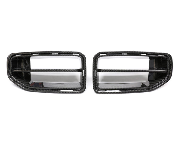 Two carbon fiber car grilles are placed side by side against a white background. Each grille features horizontal slats and a textured finish, indicative of automotive parts.