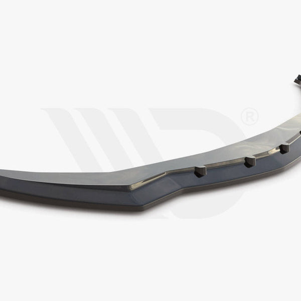 A black car front splitter with angular design and six protruding tabs sits on a plain white background. Text reads: "WORLDWIDE LEADER IN AERODYNAMIC COMPONENTS."
