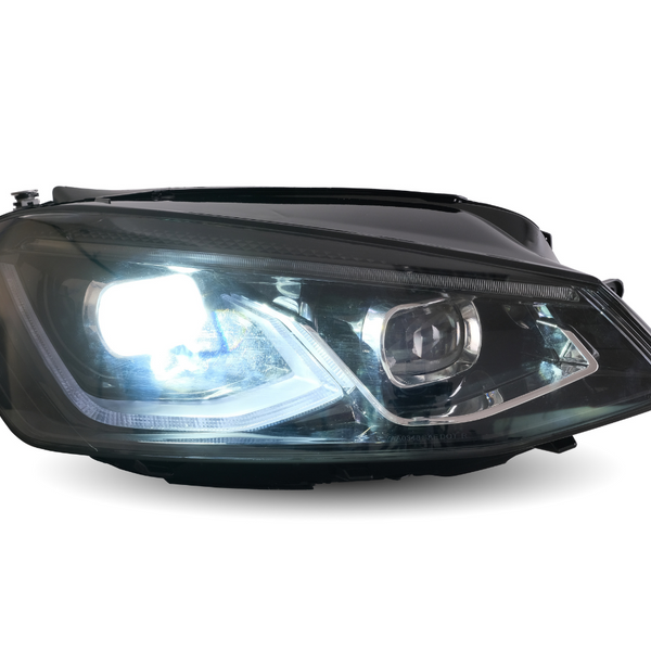 A car headlight is illuminated brightly, showcasing its reflective interior design, set against a neutral, white background.