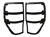 Black metal grille covers are side by side, divided into three slots each. They are intended for vehicle tail lights, set against a plain white background.