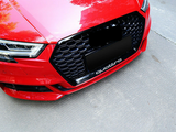 A red car displays a black honeycomb grille with 