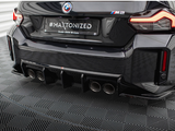 The car's rear features the BMW M2 logo, quad exhausts, and text on the license plate: 