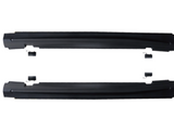 Two black, elongated car side skirts are placed horizontally, parallel to each other, against a white background. Small black brackets are positioned near them, indicating mounting components.