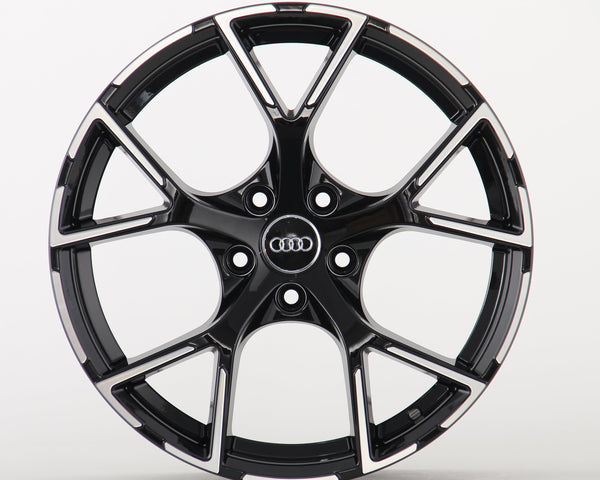 A sleek black alloy wheel with a glossy finish and five split spokes, featuring the Audi logo in the center, displayed against a plain white background.