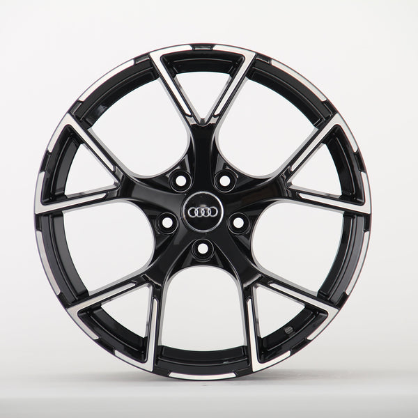 A sleek black alloy wheel with a glossy finish and five split spokes, featuring the Audi logo in the center, displayed against a plain white background.