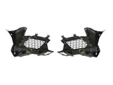 Two black plastic car components with honeycomb cutouts are symmetrically positioned. They have angular designs, suggesting automotive parts, likely for ventilation or structural support. Plain white background.