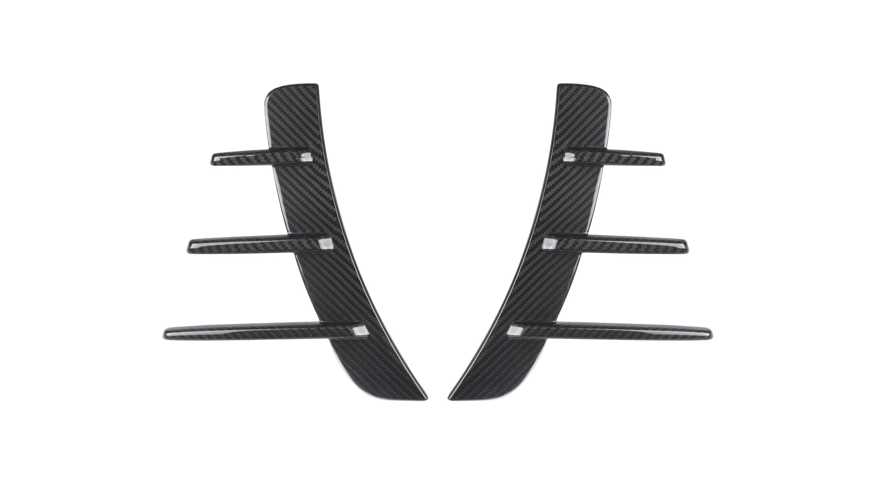 Two black carbon fiber pieces with three horizontal fins each are symmetrically aligned. They are set against a plain white background, suggesting automotive parts.