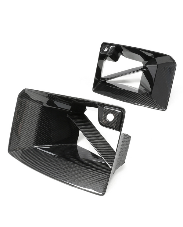 Carbon fiber air vents with a glossy finish are shown. One is angled upward and the other aligns horizontally. The white background highlights the sleek, geometric design.