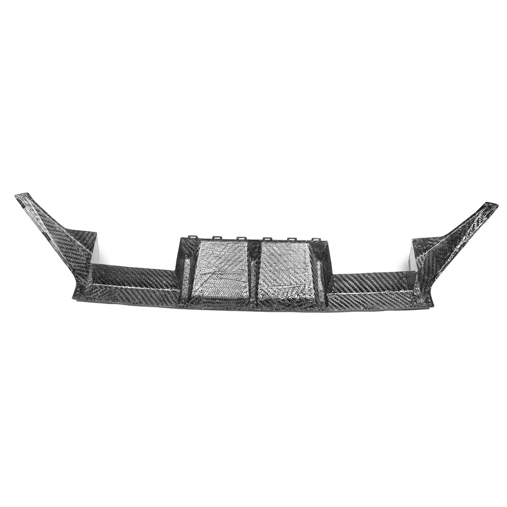 Carbon fiber car diffuser sitting on a plain white background, showcasing a sleek, angular design with multiple grooves and side fins, likely designed for aerodynamic efficiency.