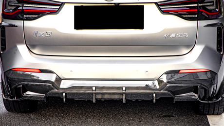 A silver car's rear with red taillights and a carbon-fiber diffuser is parked on a street. Text visible: "iX3" and Chinese characters on the back.