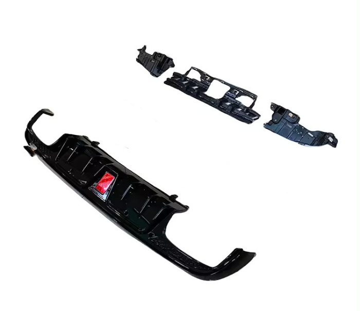Car bumper kit featuring a black front bumper and additional panel pieces, arranged on a plain white background. A small, red label is visible on the bumper.