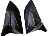 Two black, triangular plastic components face each other, displaying interior grooves and attachment points. Set against a plain white background, they appear clean and unworn, suggesting unused vehicle parts.