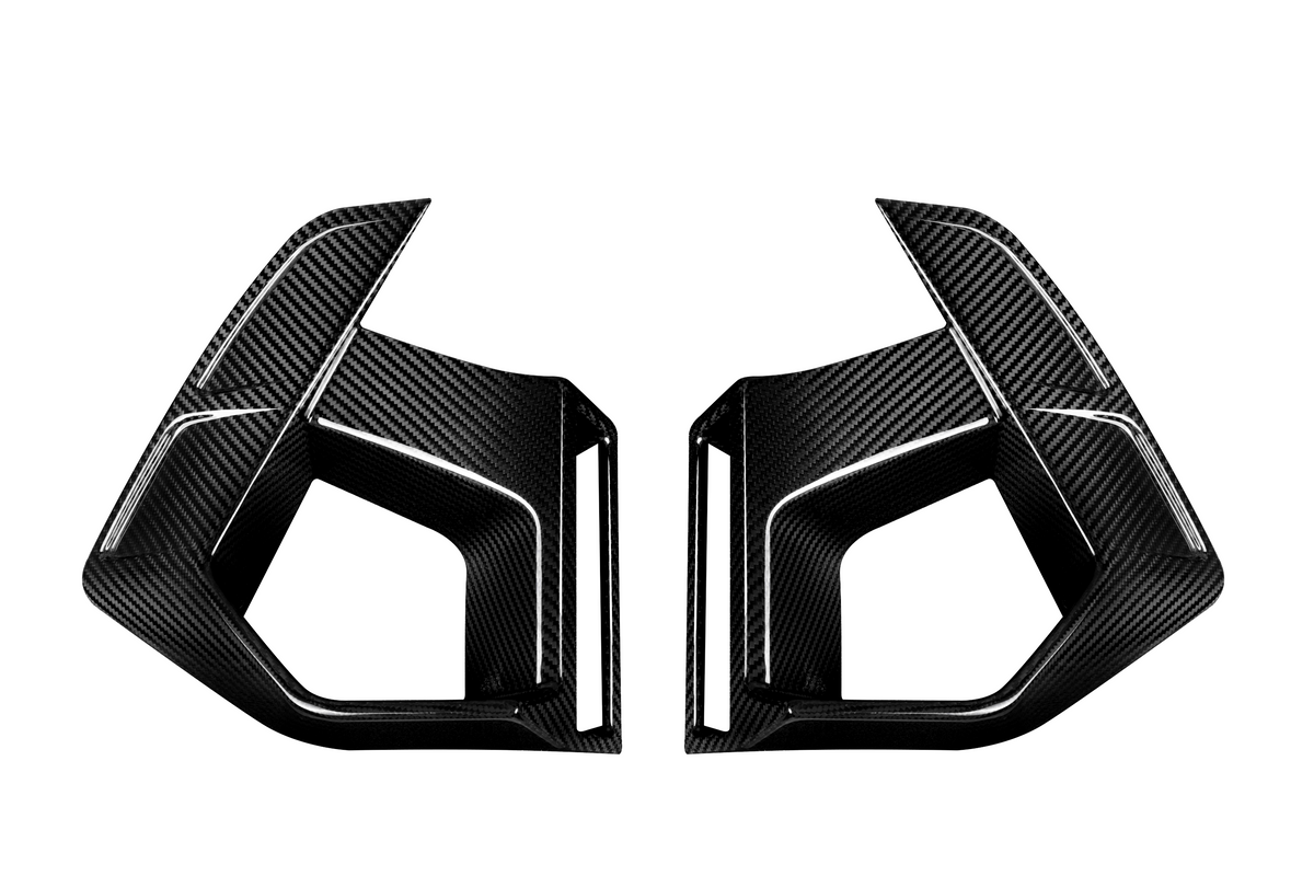 Two angular carbon fiber car parts face each other, featuring sleek lines and sharp edges, set against a plain white background.