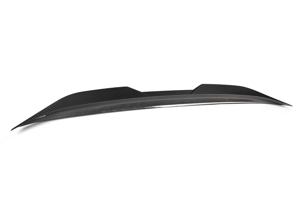 A sleek, black carbon fiber car spoiler rests against a plain white background, showcasing its aerodynamic design and smooth, modern contours.