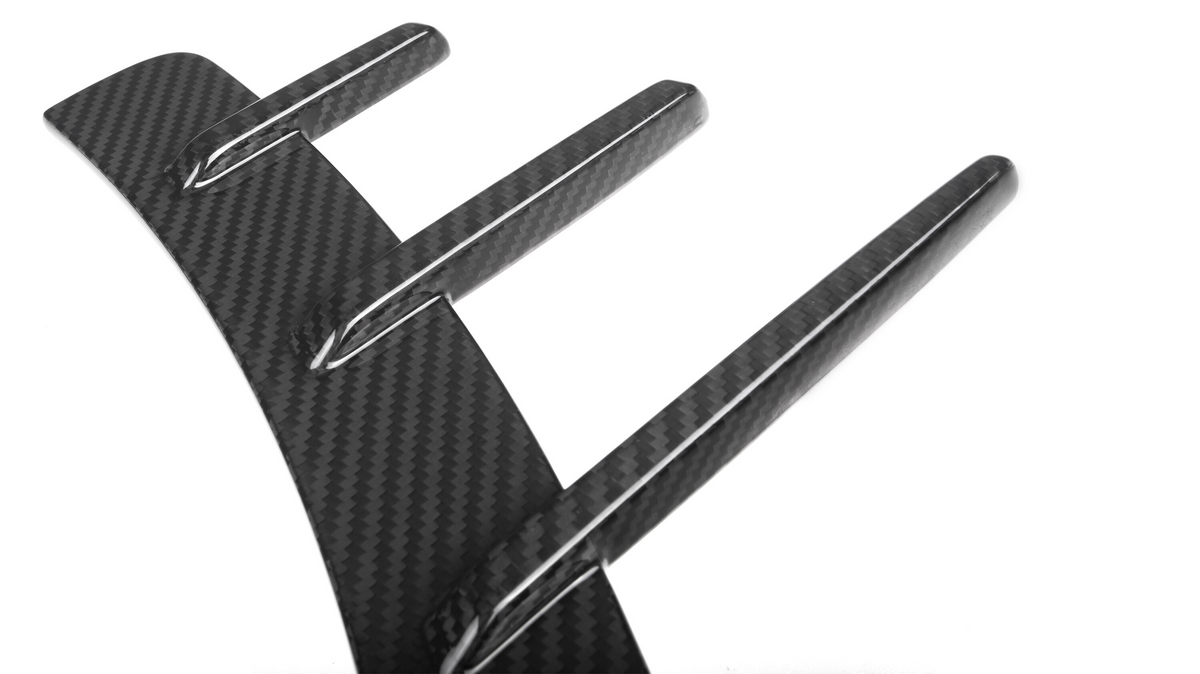 Three elongated, carbon fiber fins extending from a curved base, creating a sleek and modern pattern on a white background.