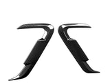 Two curved, carbon fiber-textured car accessory pieces facing each other, against a white background. They feature glossy, reflective surfaces with an angular, aerodynamic design.
