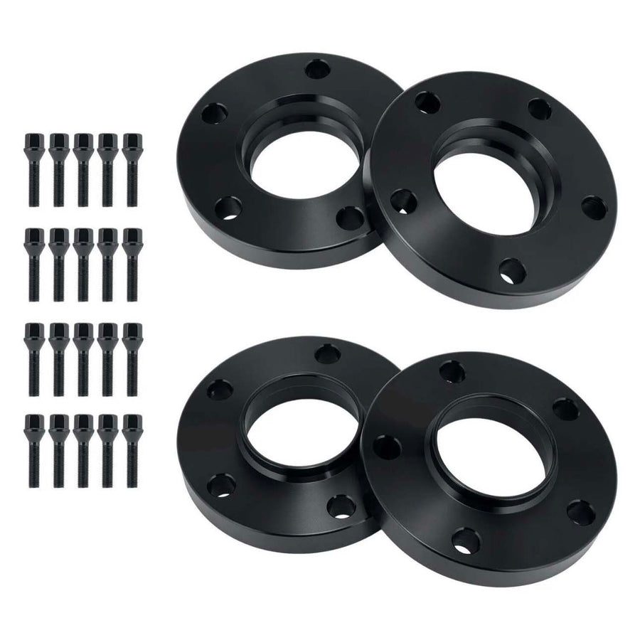 Four black wheel spacers with circular holes are laid out on a white surface, accompanied by sixteen matching screws arranged in two vertical rows.