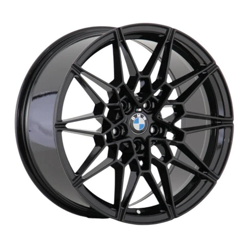 A black alloy wheel features a complex, geometric spoke design centered by a BMW logo, displayed against a plain white background.