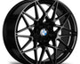 A black, multi-spoke alloy wheel with a central blue and white emblem featuring the text "BMW." The wheel displays a glossy finish with no additional context visible.