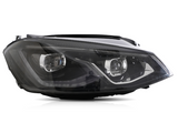 A sleek car headlight features dual reflector lamps, surrounded by black and chrome accents, isolated against a white background.