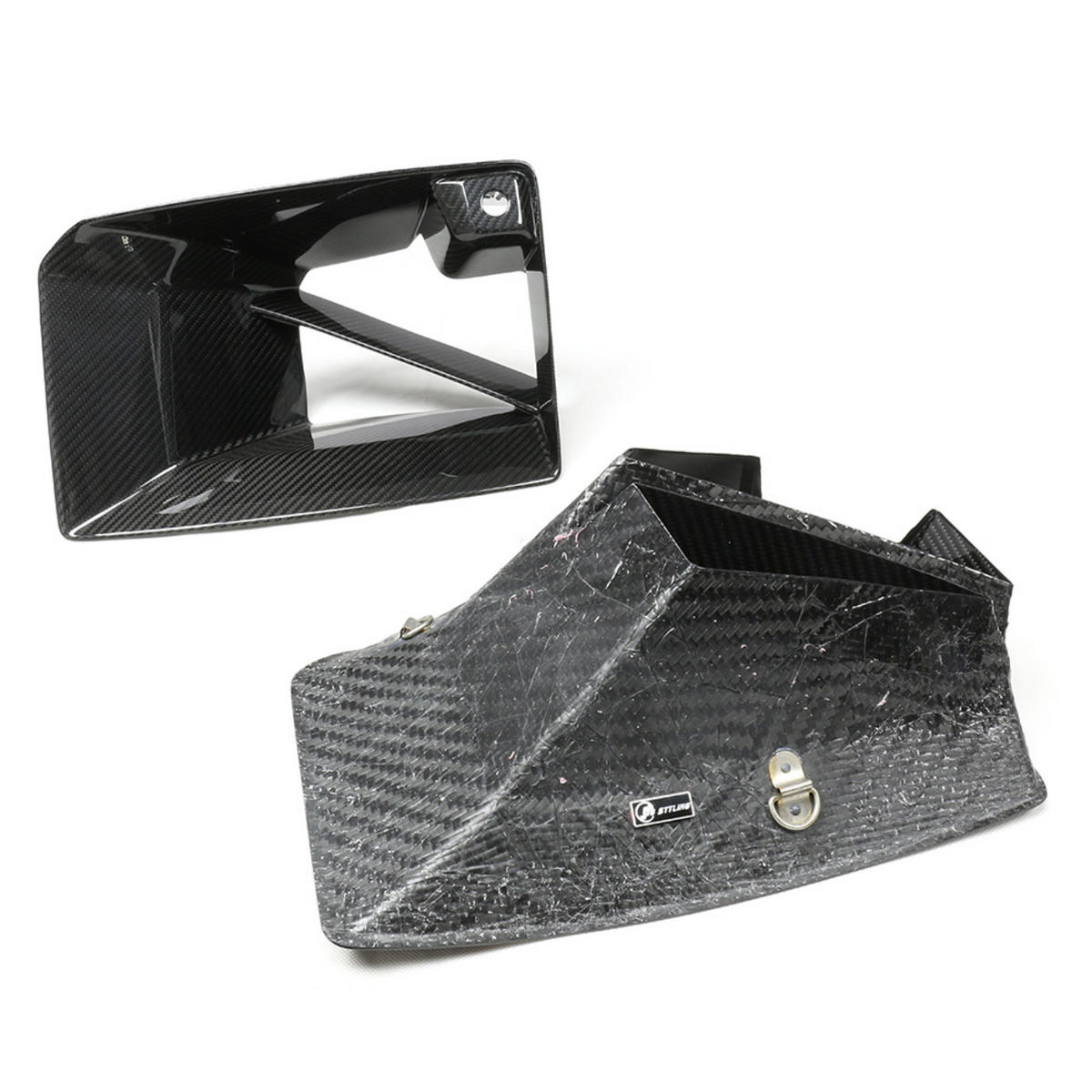 Carbon fiber intake ducts rest on a white surface, one upright and one on its side. A small silver logo reads "JETLINE" on the larger duct.