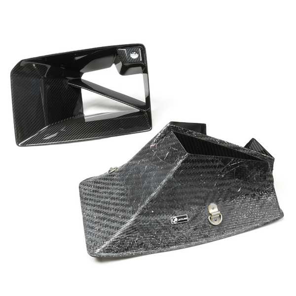 Carbon fiber intake ducts rest on a white surface, one upright and one on its side. A small silver logo reads "JETLINE" on the larger duct.