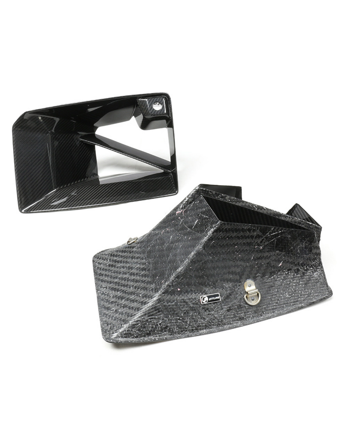 Carbon fiber intake ducts rest on a white surface, one upright and one on its side. A small silver logo reads "JETLINE" on the larger duct.