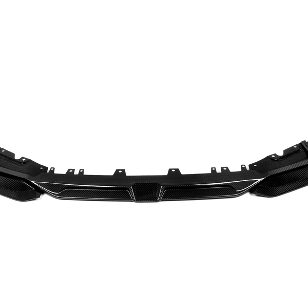 A sleek, black carbon fiber car front bumper is lying flat, designed for aerodynamic enhancement, within a plain white background for contrast.