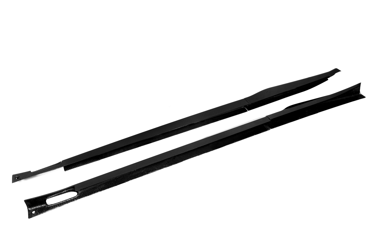 Two long, black carbon fiber strips lay parallel on a white background. One strip features an elongated hole, and both have slight angled ends.