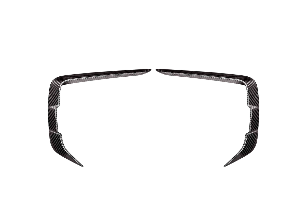 Two symmetrical, angled carbon fiber trim pieces facing each other on a plain white background, resembling elongated, curved brackets or stylized boomerangs.