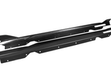 Two black carbon fiber car side skirts lie parallel, featuring aerodynamic fins and multiple mounting holes, against a plain white background.