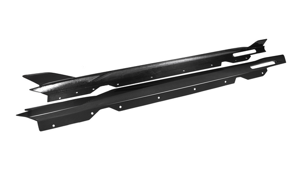 Two black carbon fiber car side skirts lie parallel, featuring aerodynamic fins and multiple mounting holes, against a plain white background.