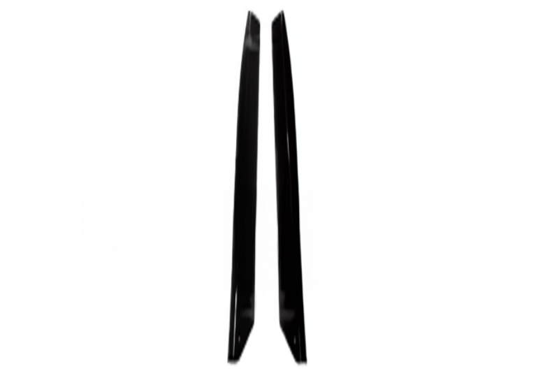 Two black objects, possibly blades or panel pieces, stand upright in parallel, facing inward against a plain white background.