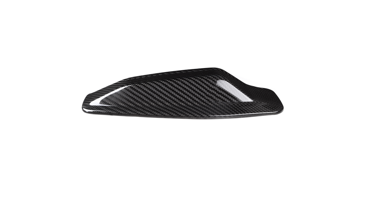 A sleek, black carbon fiber car mirror cap rests on a white background, showcasing its shiny, textured surface designed for aerodynamic enhancement.