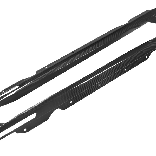 Two elongated, curved carbon-fiber automotive side skirts with mounting holes are laid side by side against a plain white background.