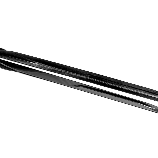 A pair of sleek black skis lies side by side, showcasing a glossy surface and streamlined design. The word "REDSTER" is visible on one ski, against a plain white background.